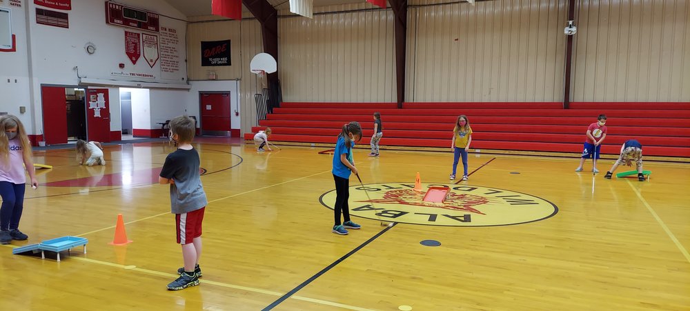 Elementary Students Playing Putt Putt Golf in gym class. 